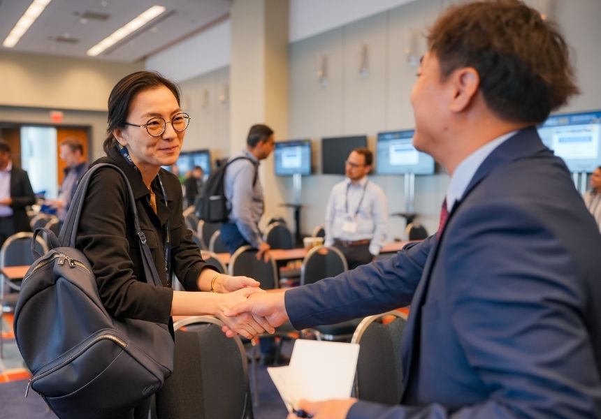 Attendees at a science conference shake hands