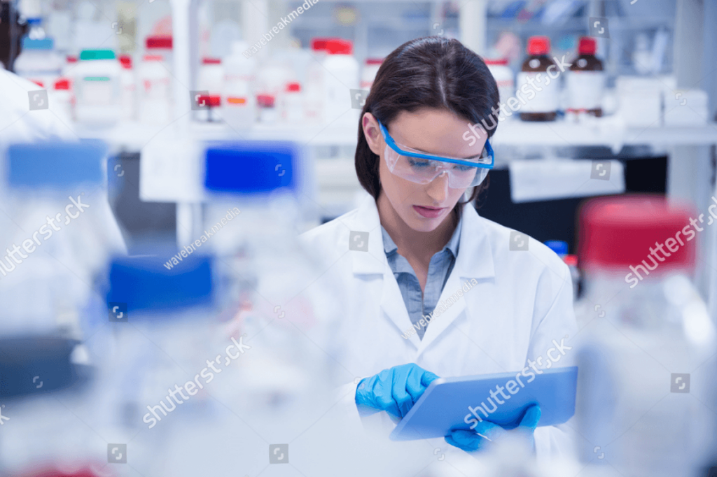 scientist in lab using a tablet with gloves on and hair not tied back