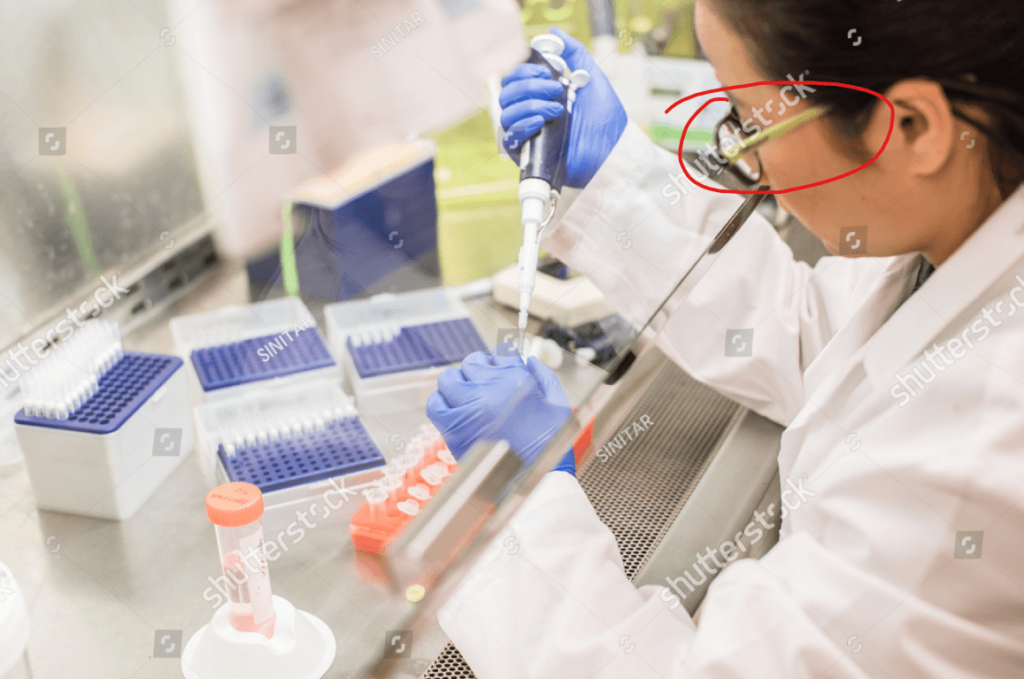 same image of a scientist correctly using a pipette in the lab with only potential issue of safety glasses not being worn, but with the glasses area circled in red